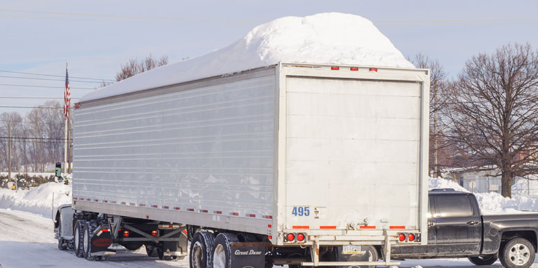 Truck driving with snow on trailer