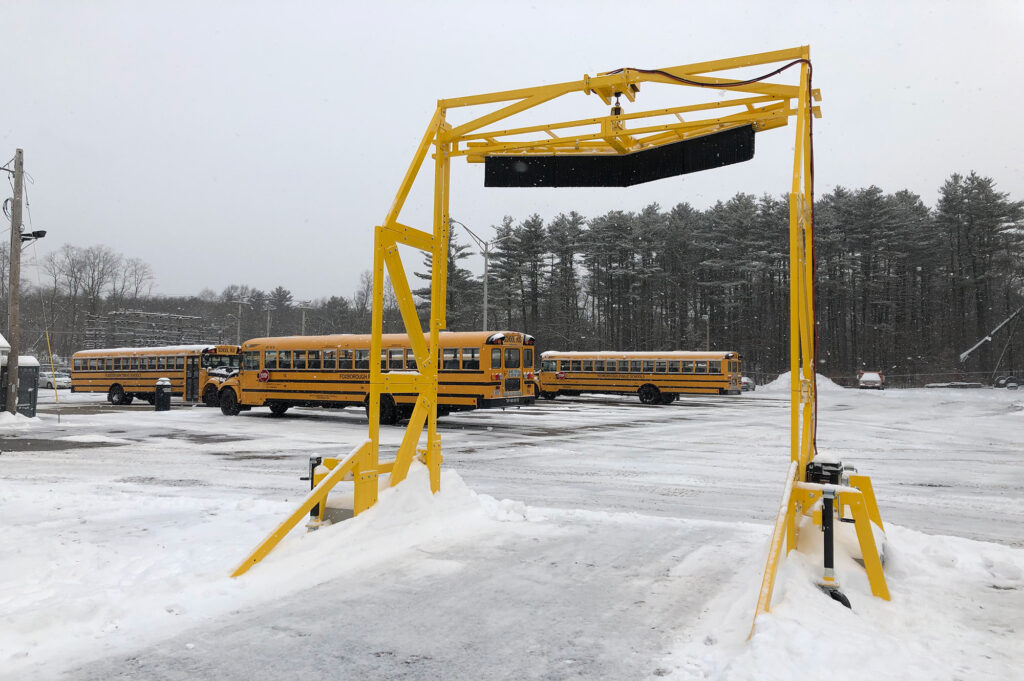 The Scraper Systems™ Fleet Plow MD-12B displayed in a parking lot with multiple school buses in the background